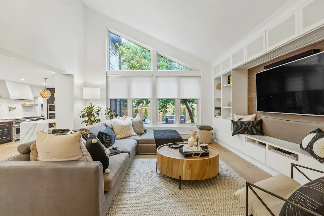 A bright living room with a large wall-mounted TV above built-in shelves, the kind of screen for Glomax8K 4K IPTV