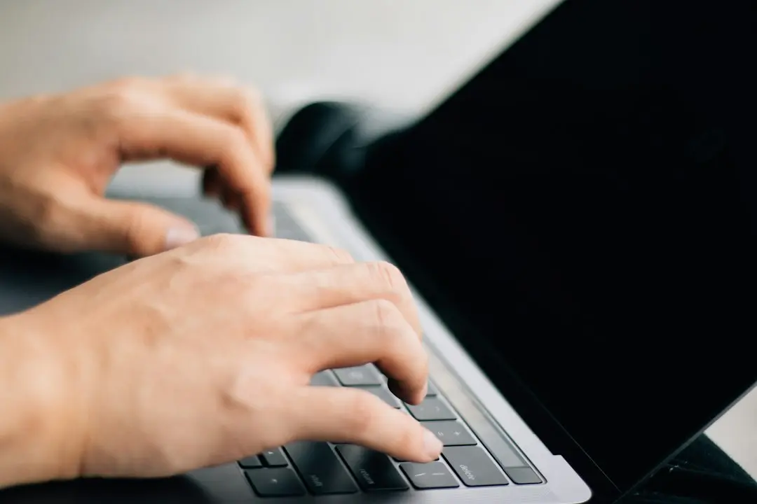 Hands typing on a laptop keyboard, as when entering Glomax8K M3U or Xtream Codes login details